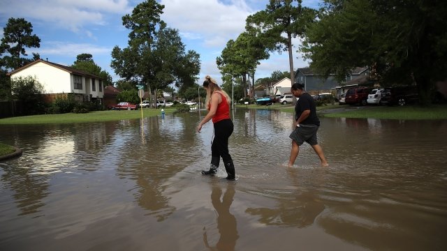 Two women walk through a flooded neighborhood street in Houston following Hurricane Harvey.