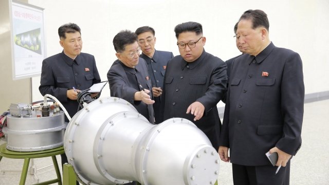 Kim Jong-un and others look at a bomb