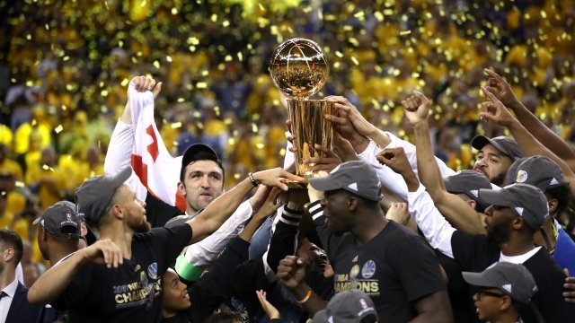 Golden State Warriors hold the Larry O'Brien Championship Trophy