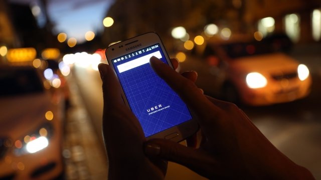 A person holds a phone with the Uber app