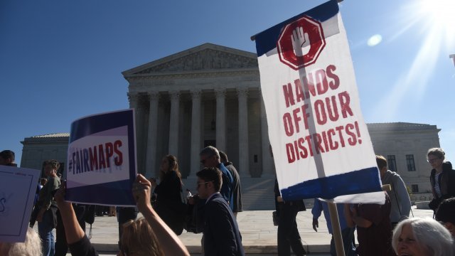 Demonstrators gather outside of The United States Supreme Court during an oral arguments in Gill v. Whitford