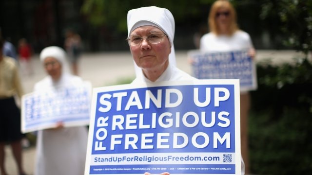 A nun holds a sign for religious freedom