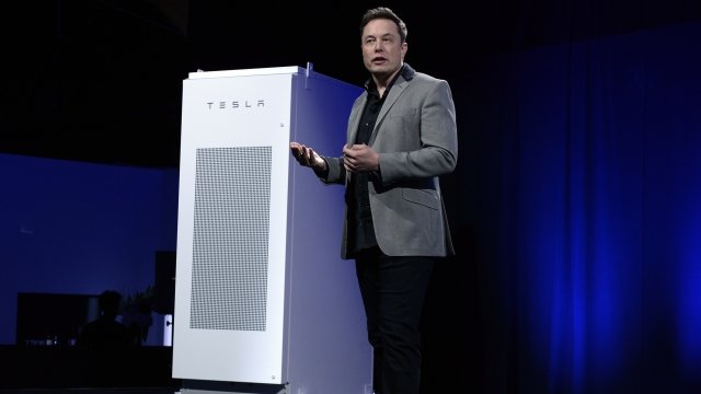 Elon Musk in front of a Tesla powerpack