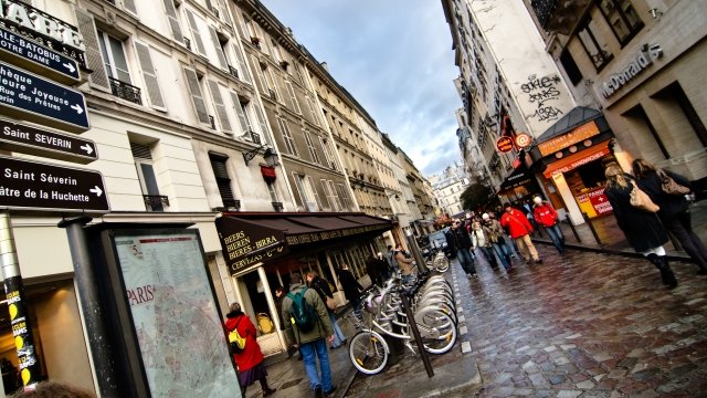 People walk down Parisian street.