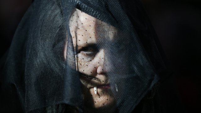 A woman dressed as a vampire shows her fangs at the Shocktober Fest on October 5, 2013