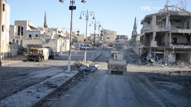 Military trucks roll through Raqqa, Syria.