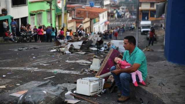 A man and child rest while waiting to buy food in Venezuela