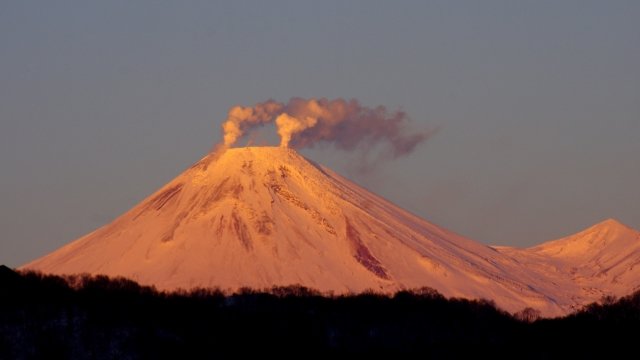 Volcano releasing smoke at sunset