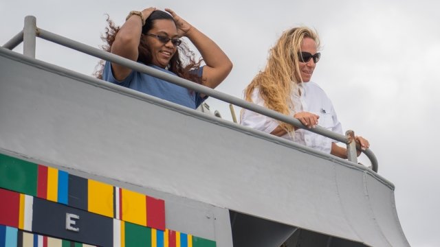Natasha Fuiava, left, and Jennifer Appel look out from the amphibious dock landing ship USS Ashland