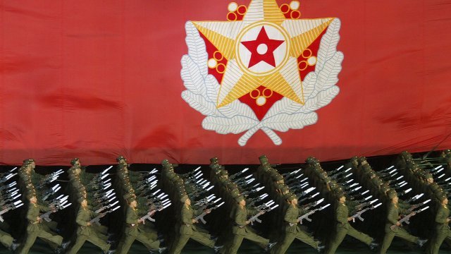 North Korea military in front of leader Kim Jong-II's flag