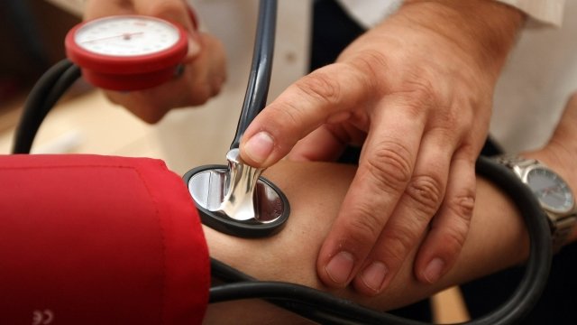 A doctor measures a patient's blood pressure