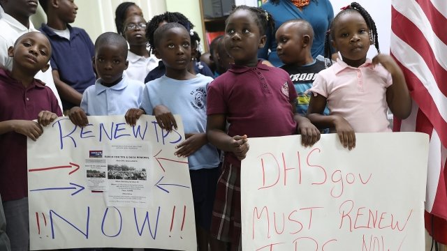 Children hold posters asking the federal government to renew Temporary Protected Status for Haitians.