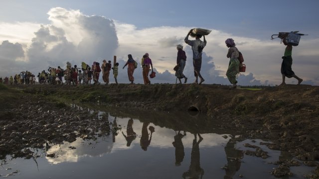Rohingya, carrying belongings, flee to Bangladesh