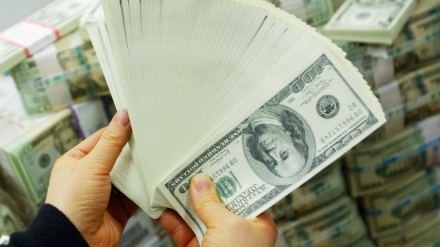 A banker carries U.S. dollar bank notes.