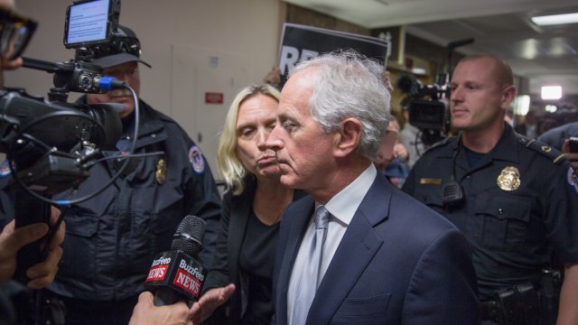 Sen. Bob Corker near committee room with protesters and reporters