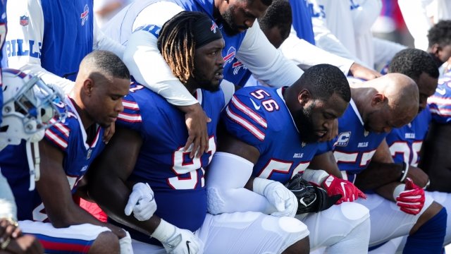Bills players kneel during the anthem at a game.