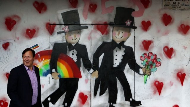 Australian walks past graffiti celebrating same-sex marriage