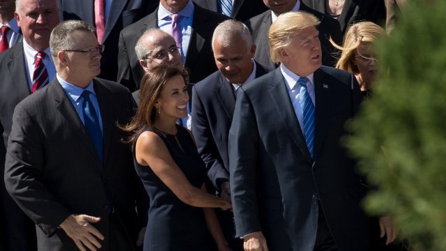 Dina Powell stands next to President Trump.