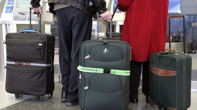 Travelers wait in airport with bags