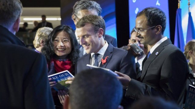 French President Emmanuel Macron surrounded by climate researchers