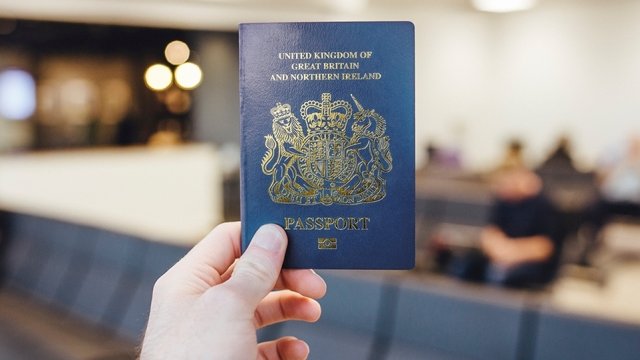 Person holds U.K. passport.