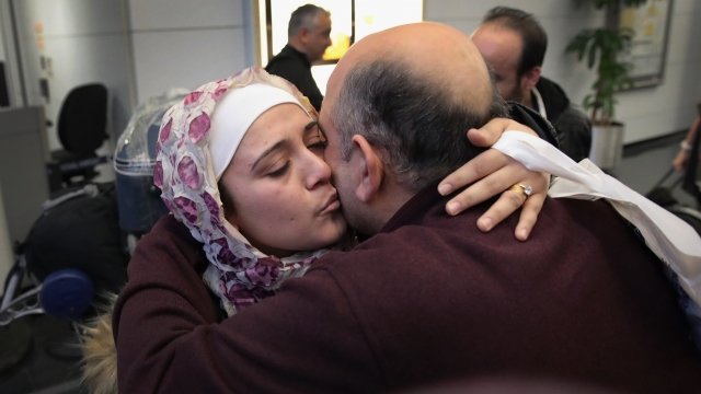 A Syrian refugee meets her father at a U.S. airport.