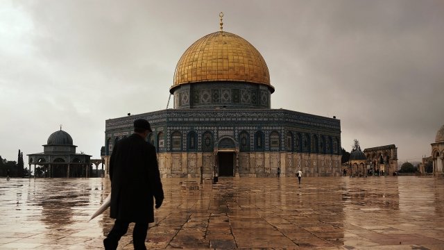 A person walks in front of the Dome of the Rock in Jerusalem.