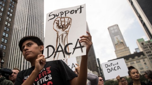 Man holds a sign in support of DACA