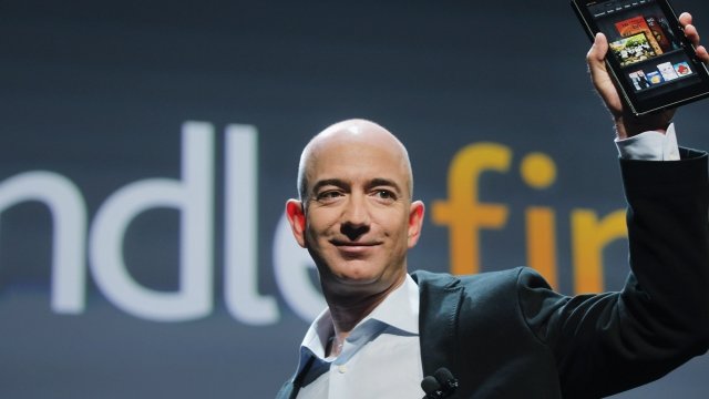 Amazon CEO Jeff Bezos holds a Kindle.