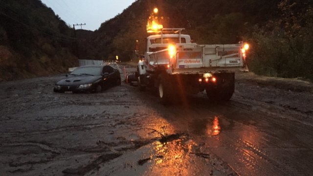 Rescue crews try to help stuck vehicle in mudslide