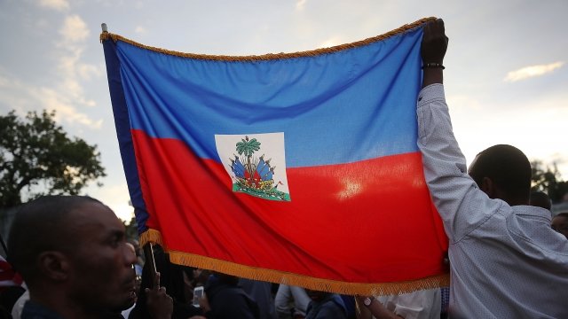 People hold the flag of Haiti