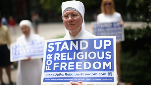 People hold signs advocating for religious freedom