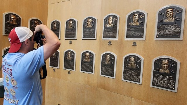 A fan takes a photo of Hall of Fame plaques.