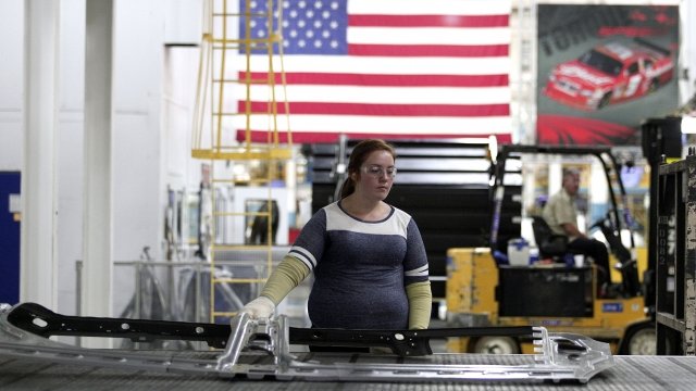 A worker handle parts for Fiat Chrysler Automobiles as they come off the press.