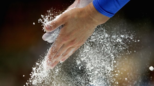 A gymnast rubs powder in hands