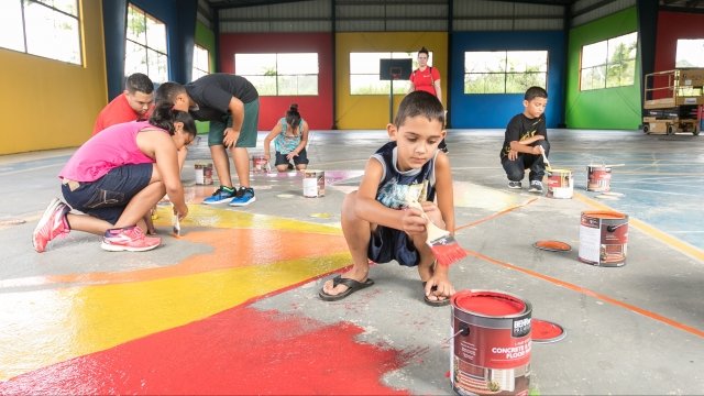 Children paint renovated gymnasium in Puerto Rico.