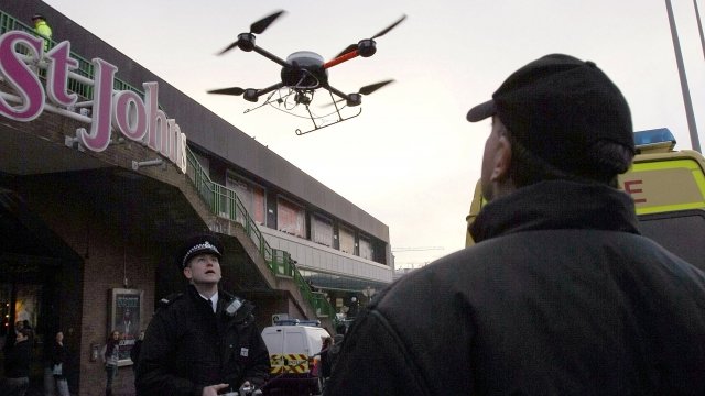 Police officers control a drone in Liverpool, England
