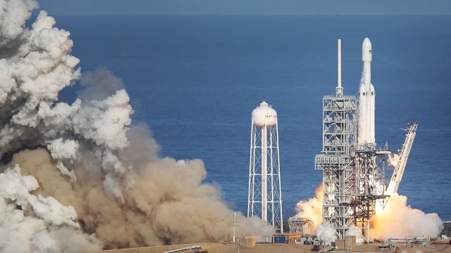 SpaceX's Falcon Heavy lifting off amid a dust cloud