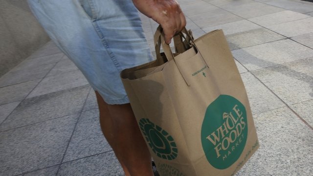 A customer carries his Whole Foods Market bag.