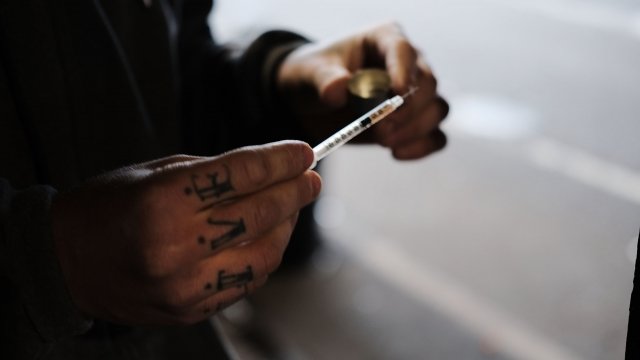 A man prepares a heroin for injection