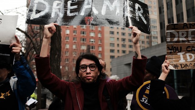 Man holding sign at protest over DACA