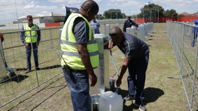 Person filling water jugs in Cape Town, South Africa.