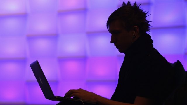 A participant sits with a laptop computer at the Chaos Communication Congress
