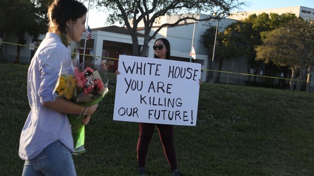 Karissa Saenz, a senior at Marjory Stoneman Douglas High School, holds a sign.