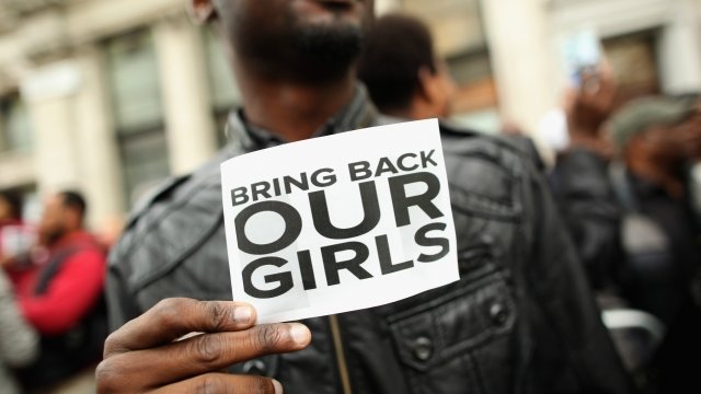 A man holds a sign reading "bring back our girls"