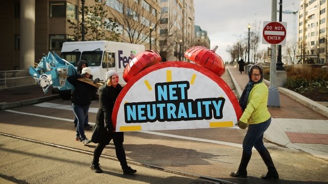 People carry a net neutrality prop