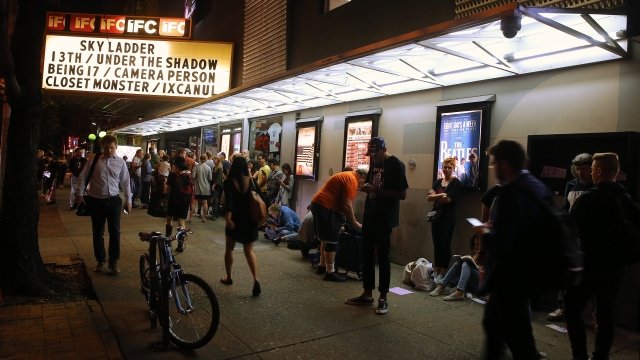 Individuals wait in line for movie tickets