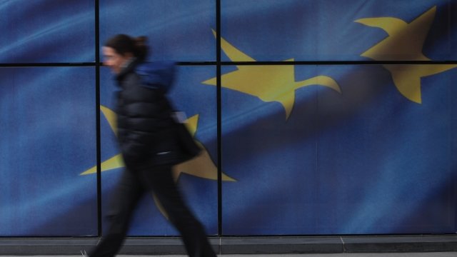 Person walks in front of European Union flag