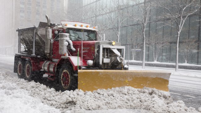 A snow plow clears a road.