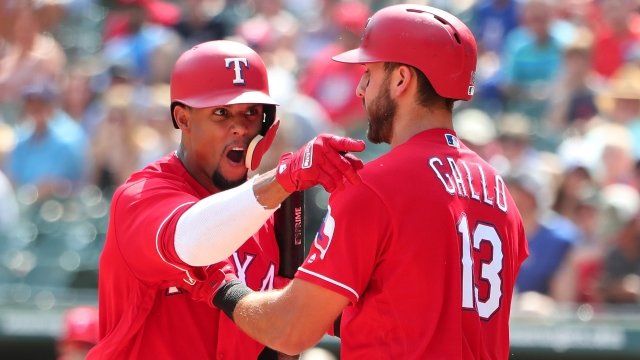 Carlos Gomez shouts at an umpire in a red Rangers uniform